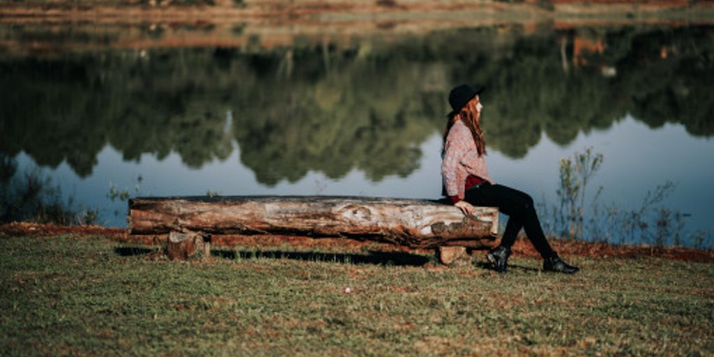 person painting on canvas in serene nature setting